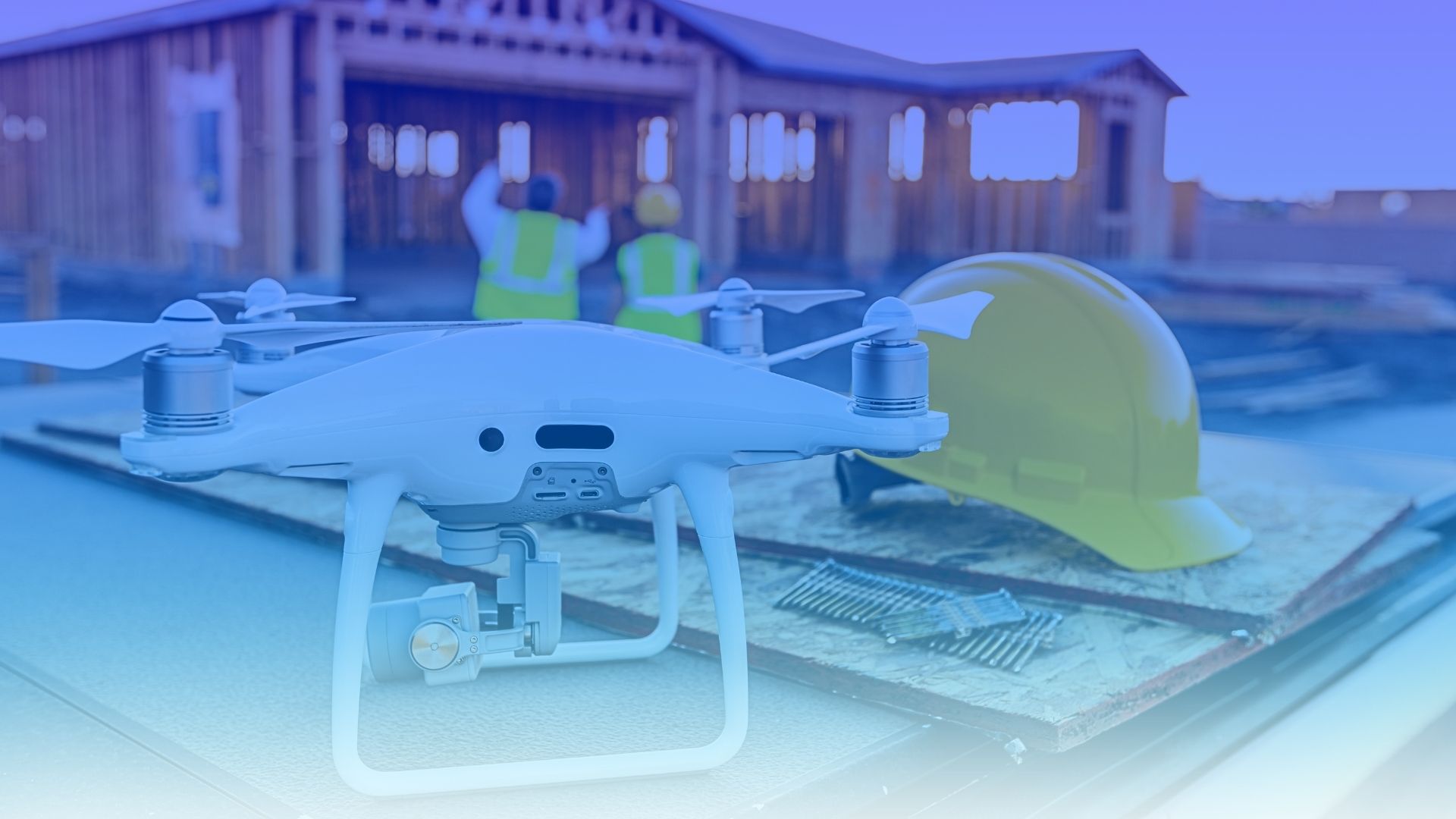 Dron y casco de obra frente a una construcción en curso